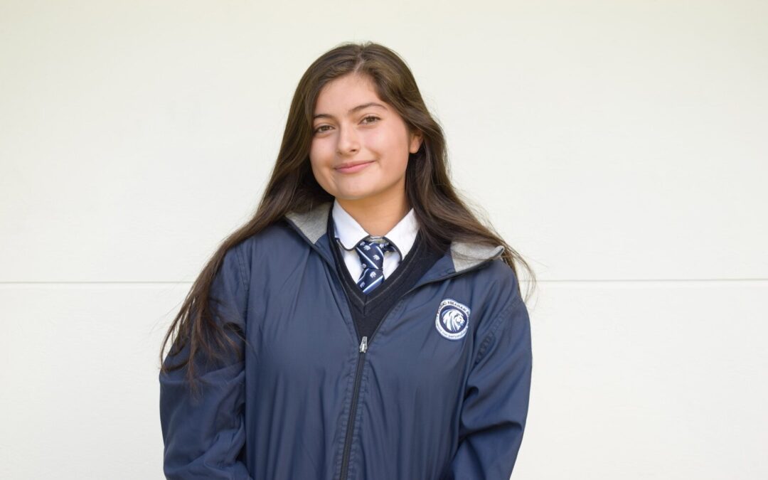 A young girl wearing a blue jacket and tie
